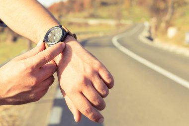 Adam yol tarafında kol saati zamanında kontrol eller