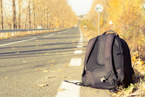 Mochila en el lado de la carretera como concepto de viaje —  Fotos de Stock