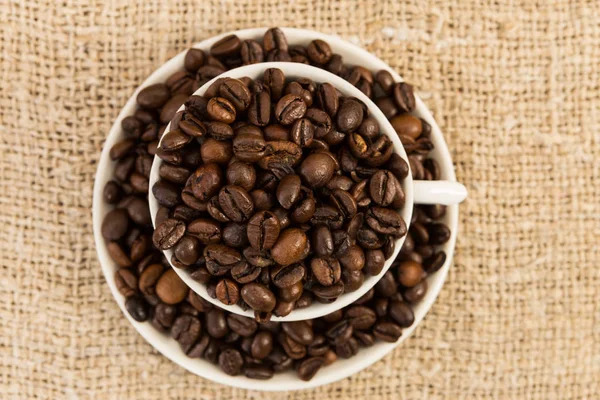 Vista superior da xícara de cerâmica de café com grãos torrados — Fotografia de Stock