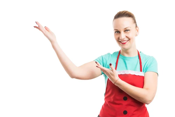 Woman wearing red apron showing or presenting copy space — Stock Photo, Image