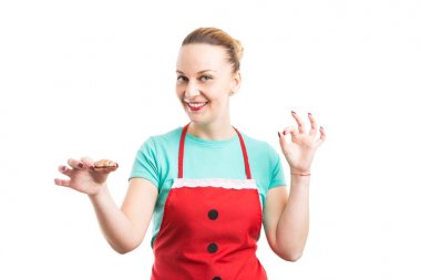 Gingerbread tutarak ve oka gösterilen kırmızı önlük ile gülümseyen kadın