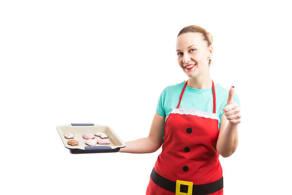 Woman with Christmas red apron holding gingerbread tray