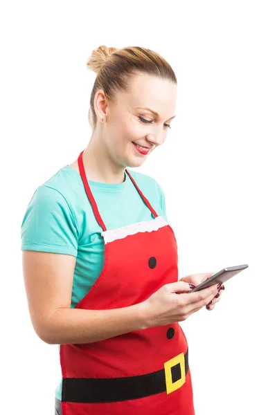 Dona de casa usando avental de Natal vermelho mensagens de texto ou bate-papo — Fotografia de Stock