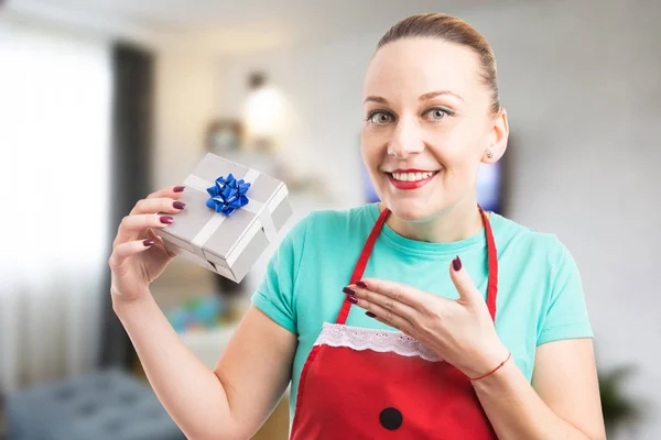 Feliz e surpresa dona de casa segurando um presente ou presente — Fotografia de Stock