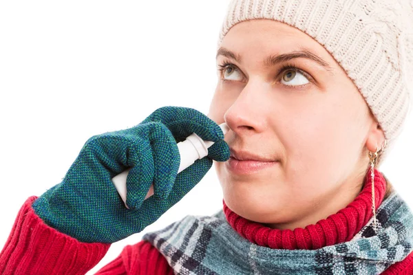 Mujer joven usando la nariz o aerosol nasal — Foto de Stock