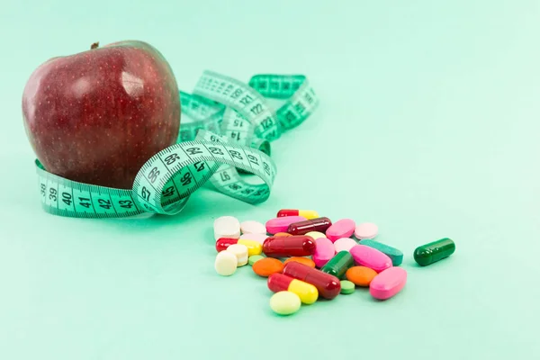 Concepto de dieta con manzana natural, cinta métrica y pastillas — Foto de Stock