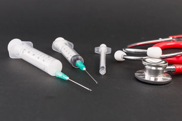 3 つのプラスチック製の使い捨て注射器、聴診器 — ストック写真