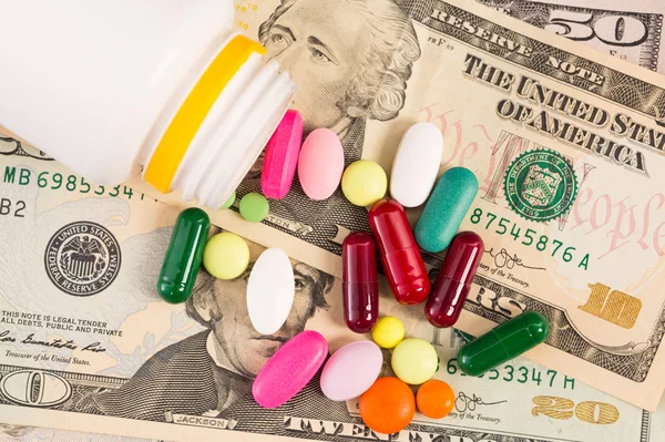 Um monte de comprimidos em notas de dólar — Fotografia de Stock