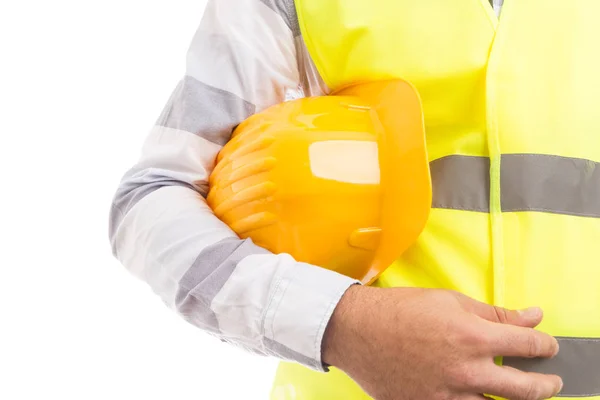 Fecho de um construtor segurando chapéu de trabalhador amarelo por baixo — Fotografia de Stock