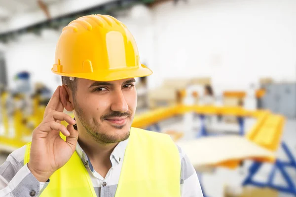 Factory worker making can\'t hear you because of noise gestur