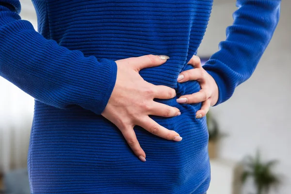 Kobieta ręce naciskając ból brzucha — Zdjęcie stockowe