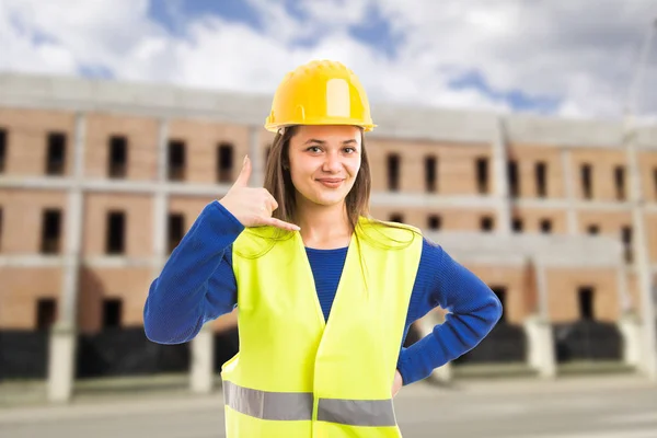 Young attractive female architect making call gestur