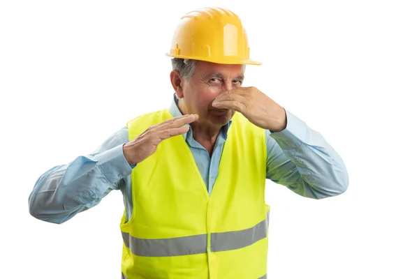 Construtor segurando nariz com a mão — Fotografia de Stock