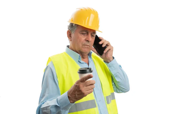 Construtor falando no telefone e segurando xícara de café — Fotografia de Stock