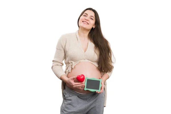 拿着心脏玩具和绿色黑板 被白色背景隔离的孕妇微笑 — 图库照片