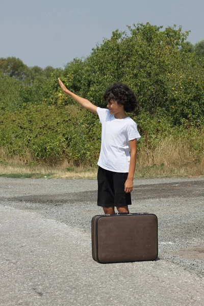 Een jongen met een oude koffer — Stockfoto