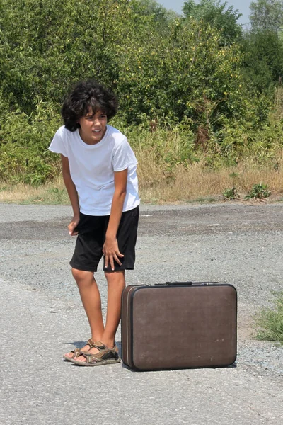 Un ragazzo con una vecchia valigia — Foto Stock