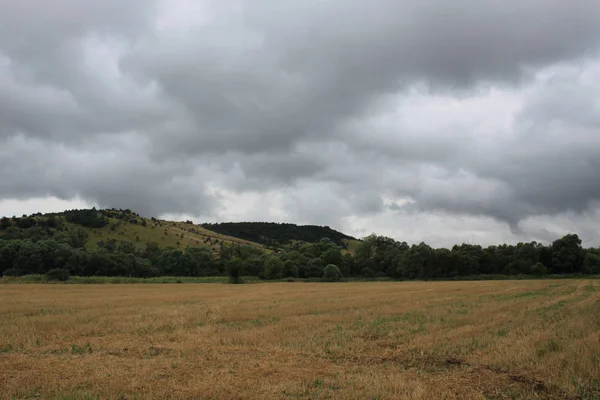 Bir alan ve bulutlar ile kırsal manzara