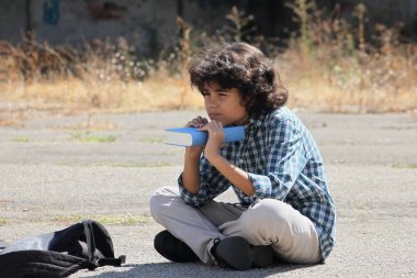 Bir kitapla kıvırcık bir öğrenci