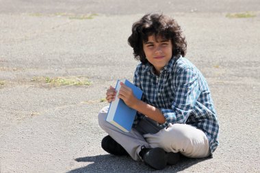 Bir kitapla kıvırcık bir öğrenci