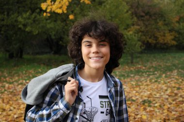 Yakışıklı bir kıvırcık çocuk bir parkta açık bir portresi