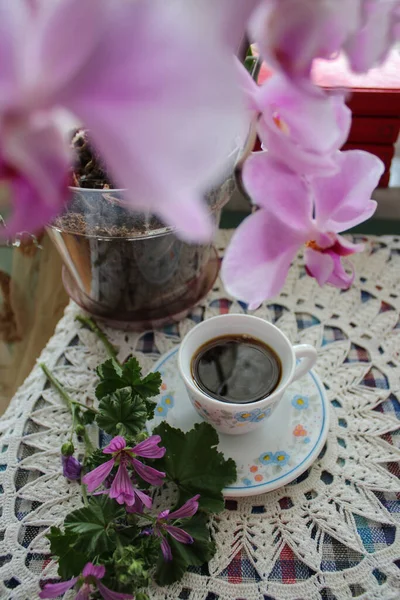 コーヒーと蘭の花と赤い本が服を着たテーブルの上でまだ生きています — ストック写真