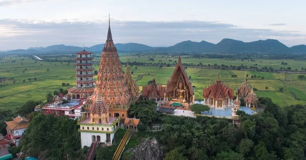 Buda heykeli altın yarım daire şeklindeki kubbe içinde mozaik ile dekore edilmiştir. Wat Tham Sua(Tiger Cave Temple), Tha Muang bölgesi, Kanchanaburi, Tayland açık bölgesinde yer alan.