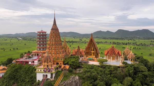 Buda heykeli altın yarım daire şeklindeki kubbe içinde mozaik ile dekore edilmiştir. Wat Tham Sua(Tiger Cave Temple), Tha Muang bölgesi, Kanchanaburi, Tayland açık bölgesinde yer alan.