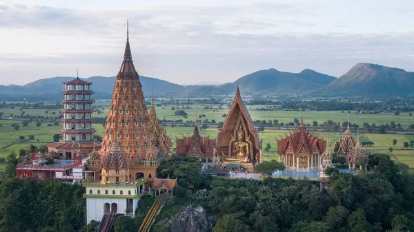 Buda heykeli altın yarım daire şeklindeki kubbe içinde mozaik ile dekore edilmiştir. Wat Tham Sua(Tiger Cave Temple), Tha Muang bölgesi, Kanchanaburi, Tayland açık bölgesinde yer alan.