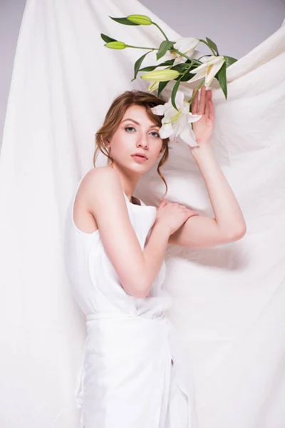 Hermosa mujer con flores de lirio — Foto de Stock