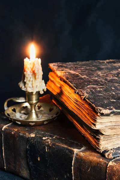 old closed books in leather cover with candle