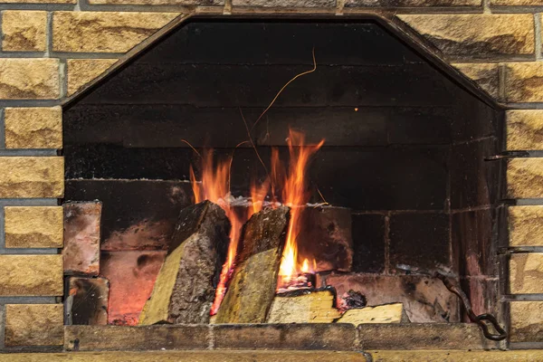 燃える火で暖炉をアーチ 薪と美しい伝統的な石の暖炉と写真広告やグリーティングレタリングのための場所 — ストック写真