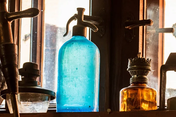 Soda için hortum. Antika eserlerle çevrili bir rafta duran klasik mavi bir soda hortumu. Renkli detaylar. Retro.