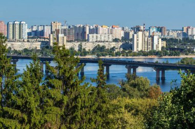 Güneşli bir günde Dinyeper, Paton Köprüsü ve Kyiv 'in Sol Kıyı manzarası. Kyiv 'in silueti. Ukrayna başkentinde doğa ve şehir manzarası bir arada. Ukrayna.