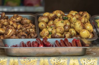 Sağlıklı yiyeceklerin sunumuyla mutfak büfesi. Mantar, patates, sosis, biber, baharat, ızgara sebze. Yiyecek pazarı, festival, etkinlik. Mutfak açık havada. Sokak panayırı.