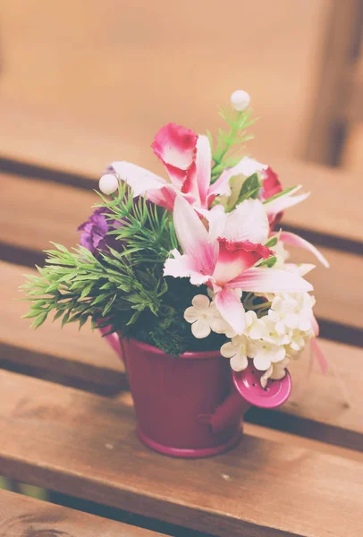 Kunstmatige bloemen In vaas op houten tafel — Stockfoto