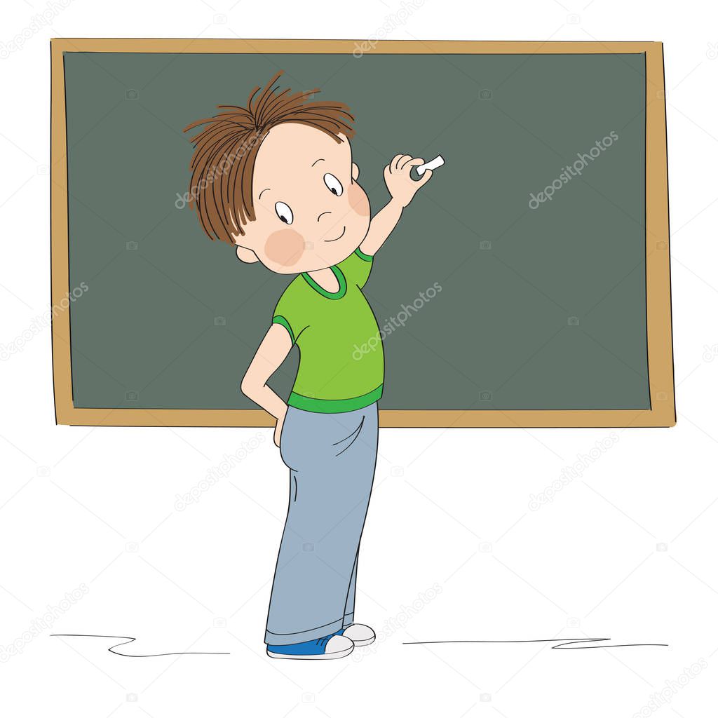 Cute little boy standing in front of the blackboard, showing something with chalk