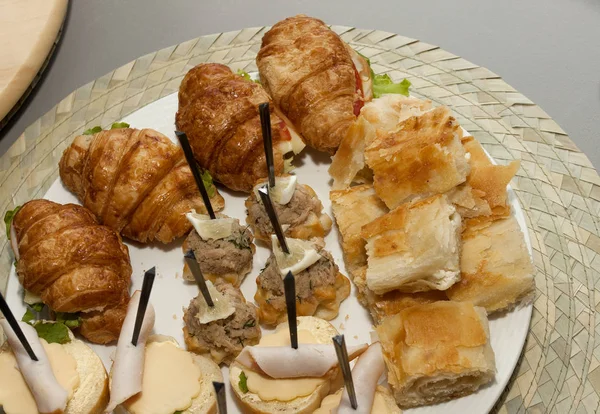 Party food closeup on a plate. Bread rolls with grapes, meat and — Stock Photo, Image