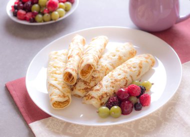 Ev yapımı krep krem peynir ve çilek beyaz tabakta, krem, kahve fincan yulaf ezmesi. Güneşli sabah. Lezzetli kahvaltı.