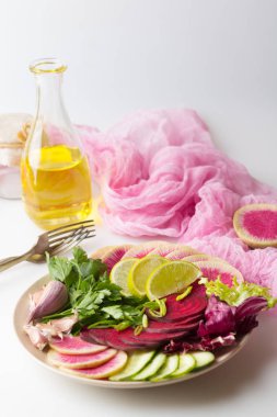 Taze salata ile pancar, karpuz turp, salatalık, maydanoz, limon, sarımsak, zeytinyağı, salata karışımı. Pembe sebze sağlıklı kavramı. Vegan gıda. Beyaz arka plan.