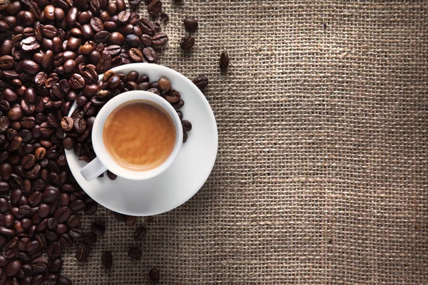 Taza de café sobre fondo saco de yute con frijoles Imagen De Stock