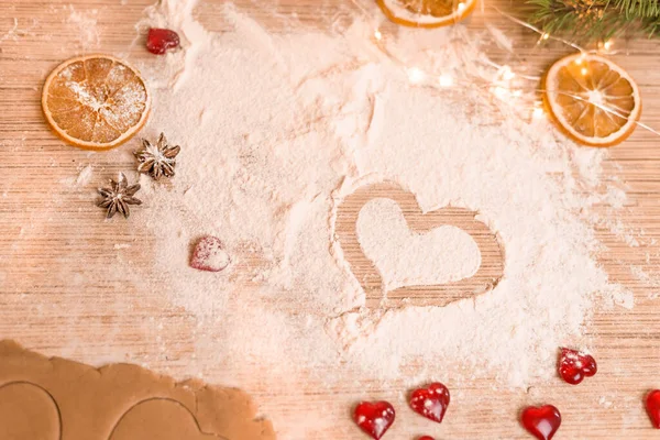 El concepto de hornear para el Día de San Valentín con antorchas en forma de corazón. el corazón se dibuja en la harina en el proceso de fabricación de galletas — Foto de Stock
