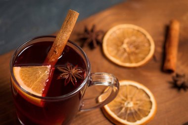 Kırmızı şarap, baharat ve portakala dayanan baharatlı şarap. köknar dalları ve portakal dilimleri olan karanlık bir arka planda. Yakın çekim, mesaj için yer. Yukarıdan görünüm