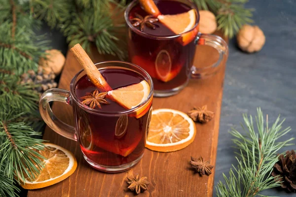 Kerst glühwein met sinaasappelschijfjes op basis van rode wijn met kruidige kaneelstokjes, steranijs, op een zwarte achtergrond. Het uitzicht op de top. — Stockfoto