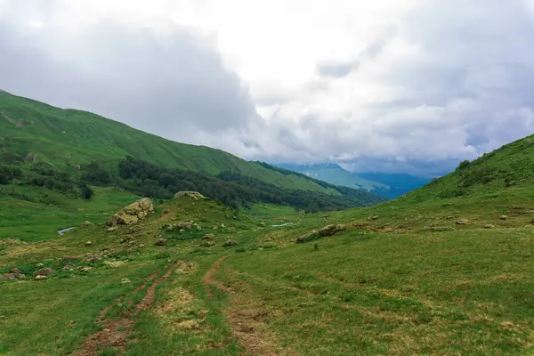 Turistaút a tóhoz. havas hegyek körül. panoráma hegyvidéki terepre — Stock Fotó