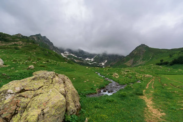 Turistaút a tóhoz. havas hegyek körül. panoráma hegyvidéki terepre — Stock Fotó