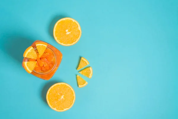Mermelada de naranja nutritiva fresca con rodajas de calabaza, desayuno saludable con una nutrición adecuada. mermelada en un frasco de vidrio sobre un fondo azul. espacio para texto — Foto de Stock