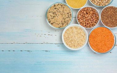 Varieties of natural organic seed in round plates of rice, millet ,lentils, buckwheat, peanuts,oatmeal. the view from the top. space for text. healthy veggie food