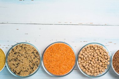 Varieties of natural organic seed in round plates of lentils, chickpeas and brown long rice . the view from the top. space for text. healthy veggie food . diet