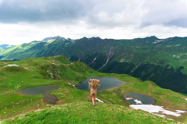 Turysta idzie górską ścieżką. Panorama alpejskich gór. turystyka górska. Szlak dla trasy spacerowej. Kaukaskie góry. letni krajobraz z górami. — Zdjęcie stockowe